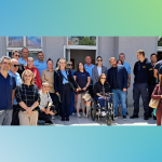 Skupna fotografija sudionika edukacije ispred zgrade, na kojoj stoje predstavnici javnih službi i organizacija osoba s invaliditetom. U skupini je i osoba u invalidskim kolicima te pas vodič.